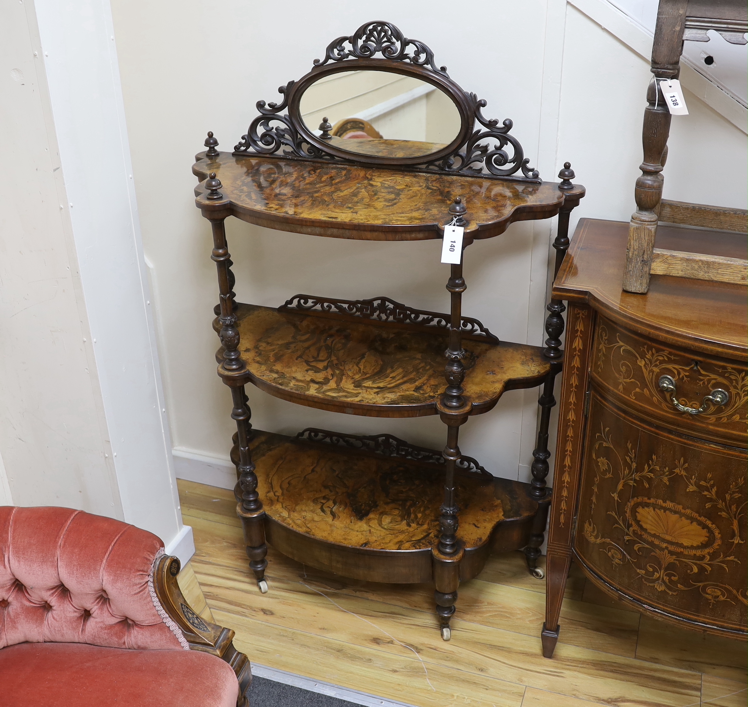A Victorian walnut and simulated walnut three tier bow front mirror back whatnot, width 93cm, depth 36cm, height 140cm